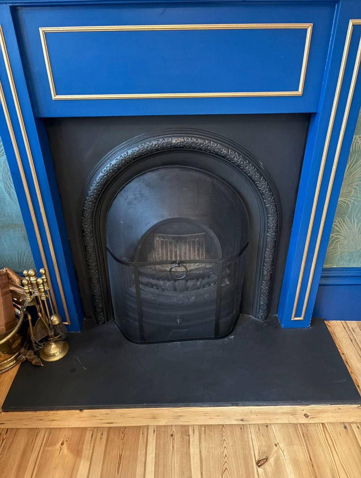 Ornate black fireplace set into a blue surround