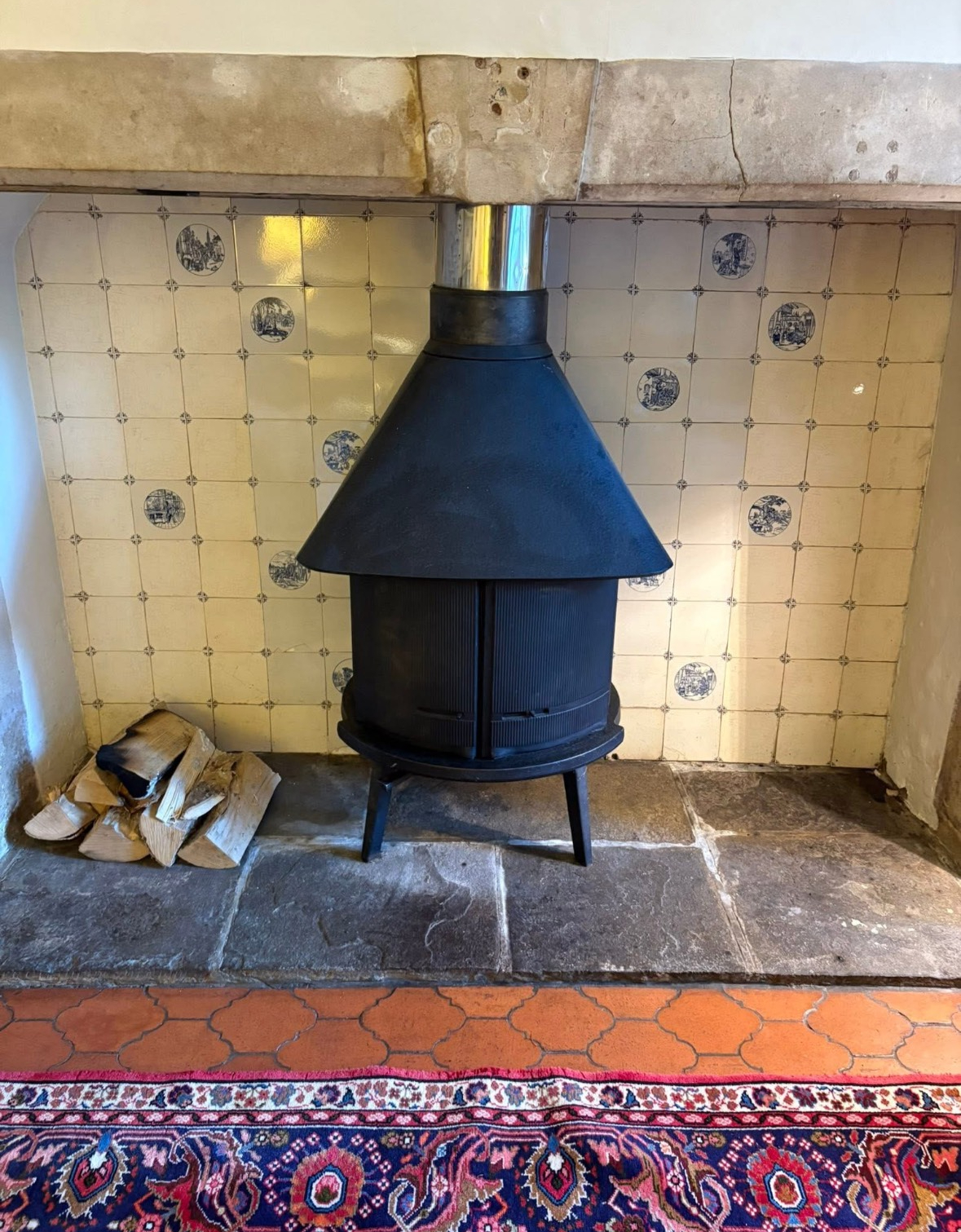 Freestanding log burner inside a clean fireplace recess